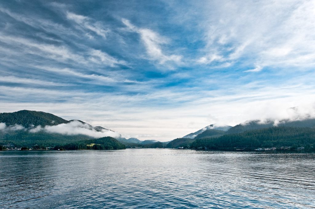 Calm sea with mountains on horizon and expansive sky in Ketchikan, Alaska. Credit: Phil Price, Flickr